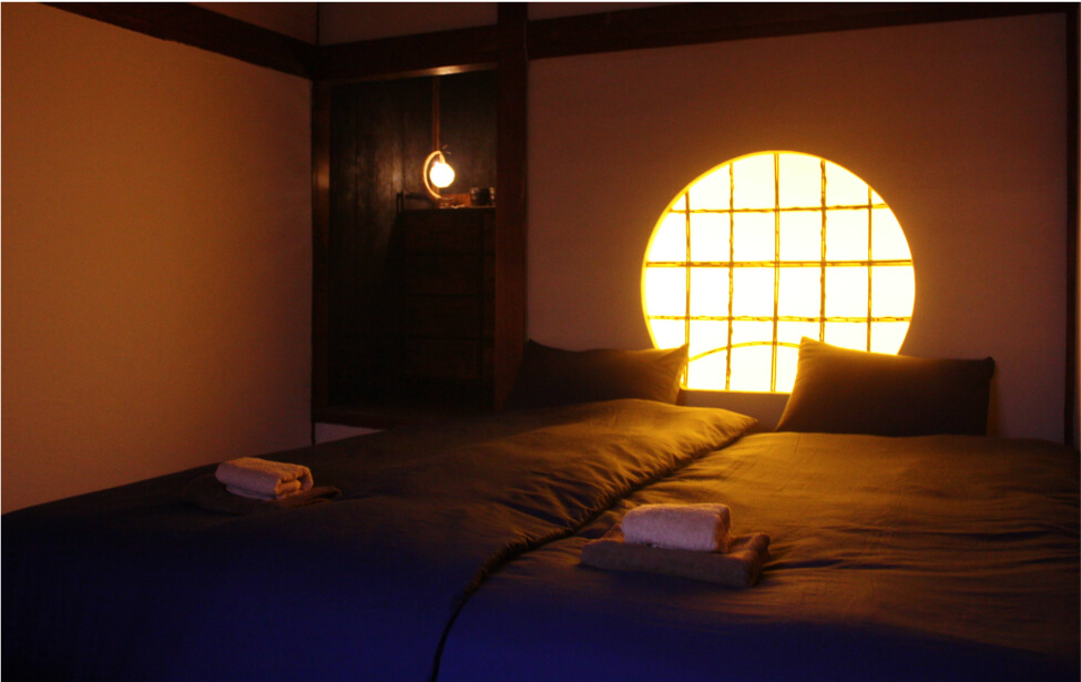 丸い障子窓のあるホテル客室